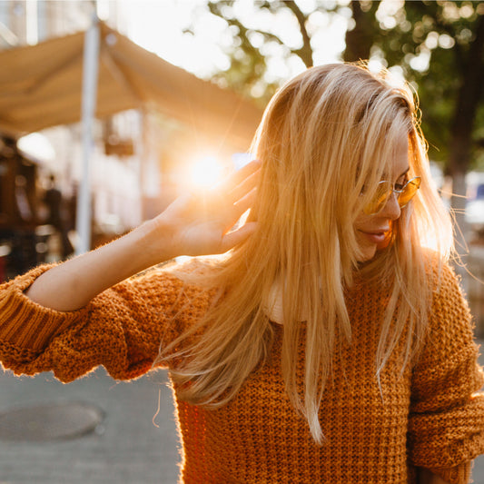 Woman at outdoor event in fall sweater.